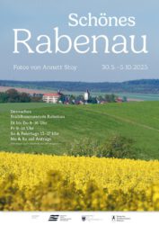 Das Veranstaltungsplakat zeigt im Vordergrund ein gelb blühendes Rapsfeld, dann eine grüne Wiese und im Hintergrund einige Häuser von Rabenau, vor allem das markante Schulgebäude.